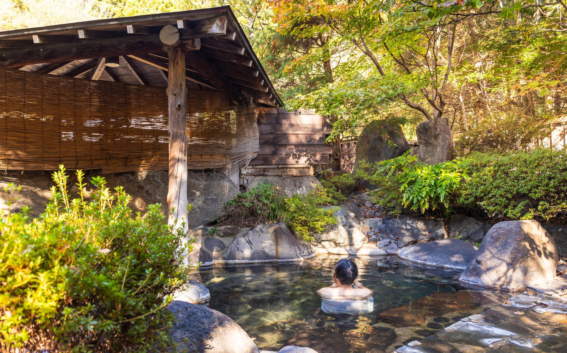 Mann som bader i en onsen, en varm vannkilde. Mann som bader i en onsen, en varm vannkilde.