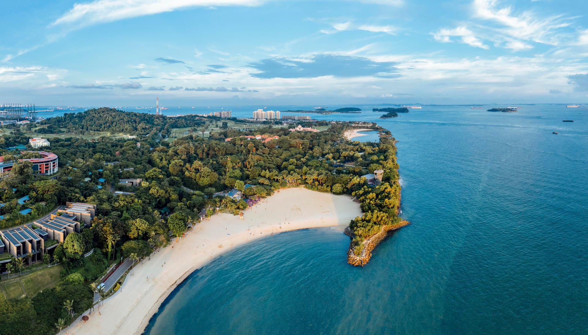 VAkker strand på Sentosa Island med skog og bygninger VAkker strand på Sentosa Island med skog og bygninger