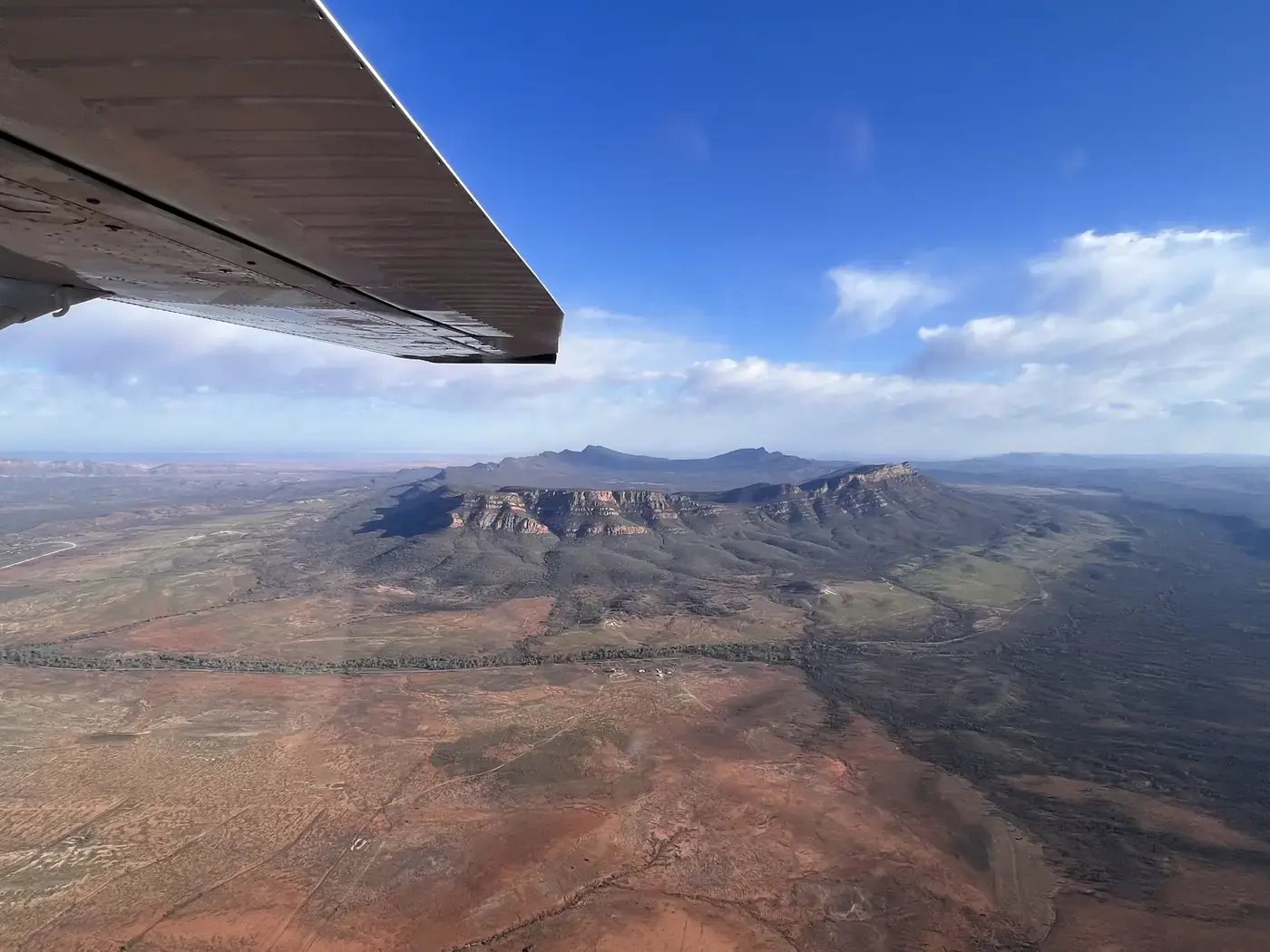 Flyfoto av Wilpena Pound sett fra småfly, med en flyvinge i øvre kant av bildet.