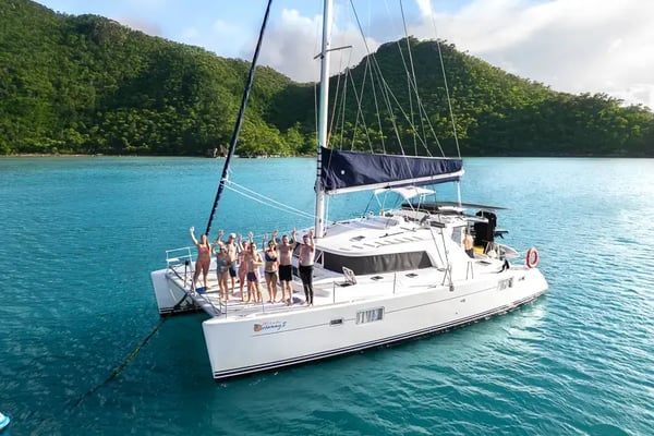 En gruppe glade mennesker på dekke av seilbåtkatamaranen whitsuunday Getaway.