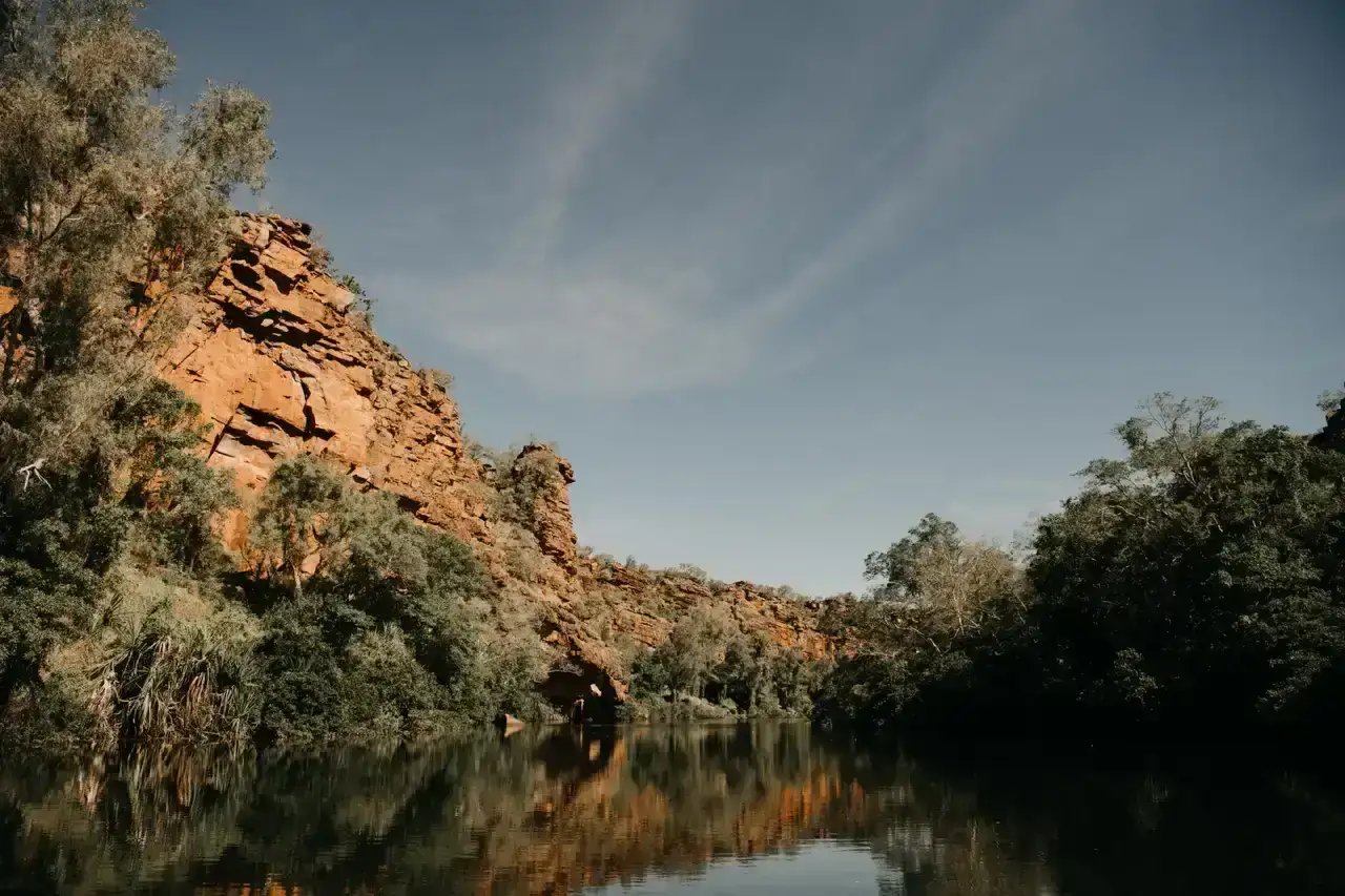 Bullo Gorge med rød klippevegg som speiler seg i elven.