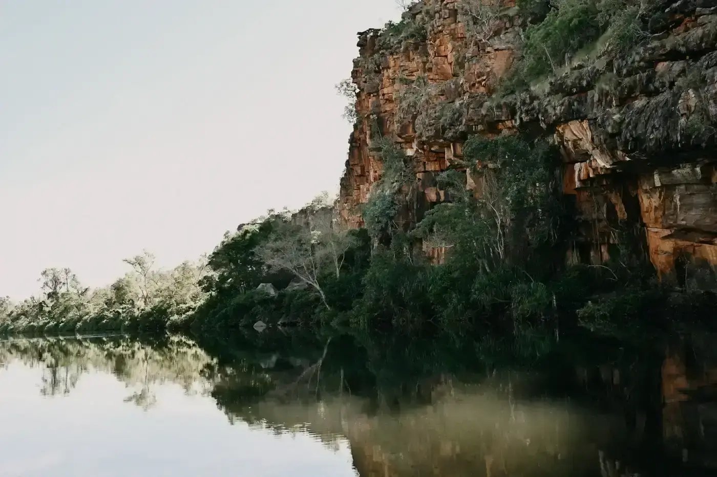 Røde klippevegger over det rolige vannet i Bullo Gorge.