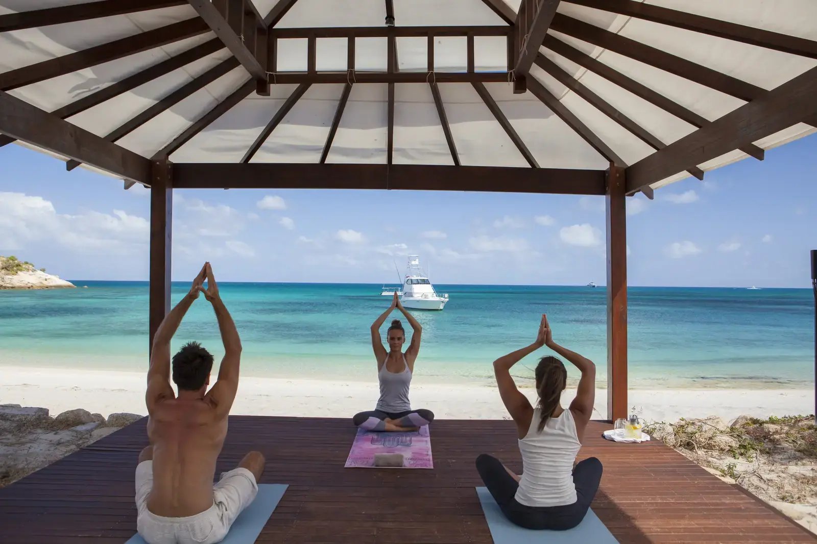Yoga på overbygd platting ved stranden.