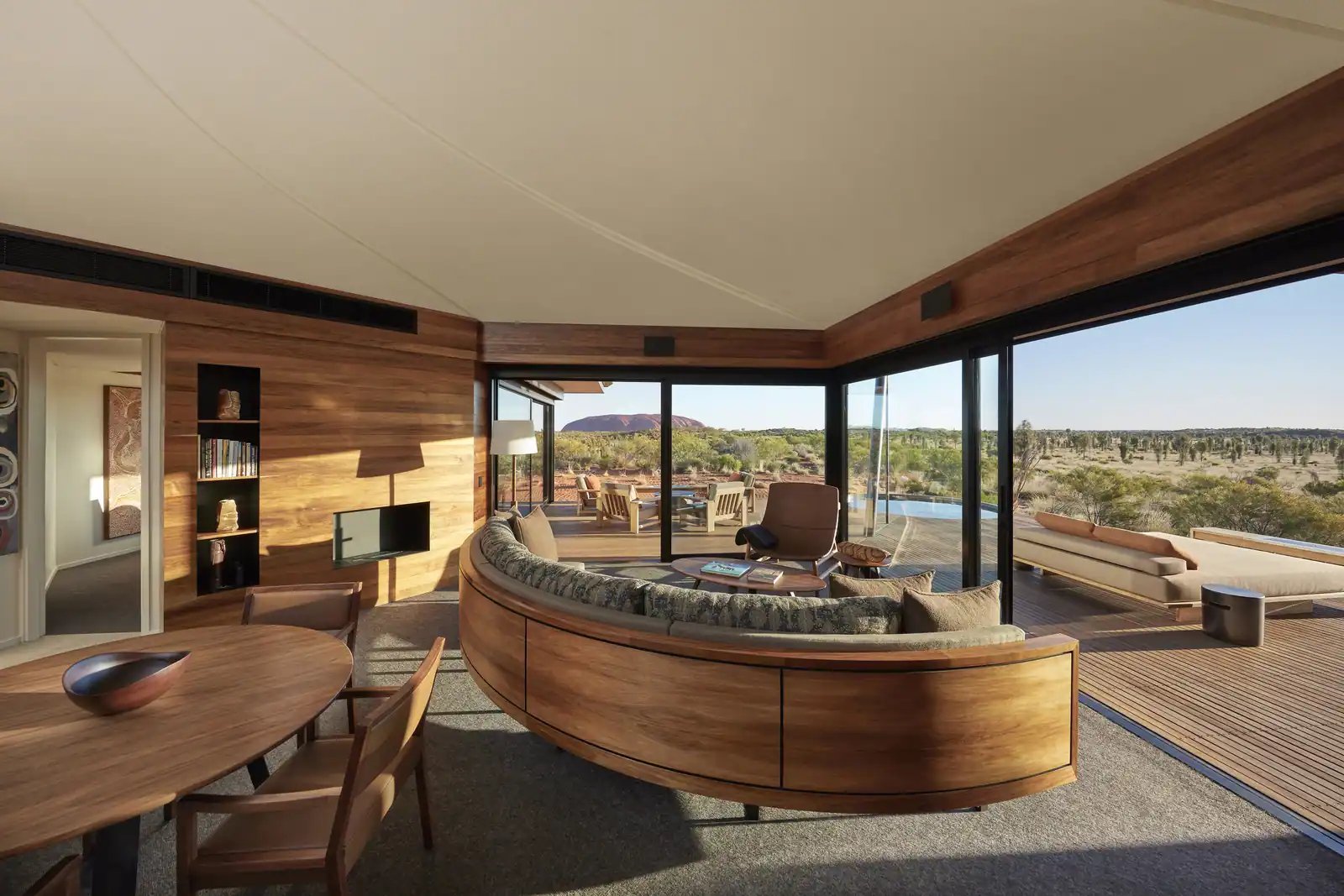 Salongen i Dune Pavilion med buet sofa og glassvegger.