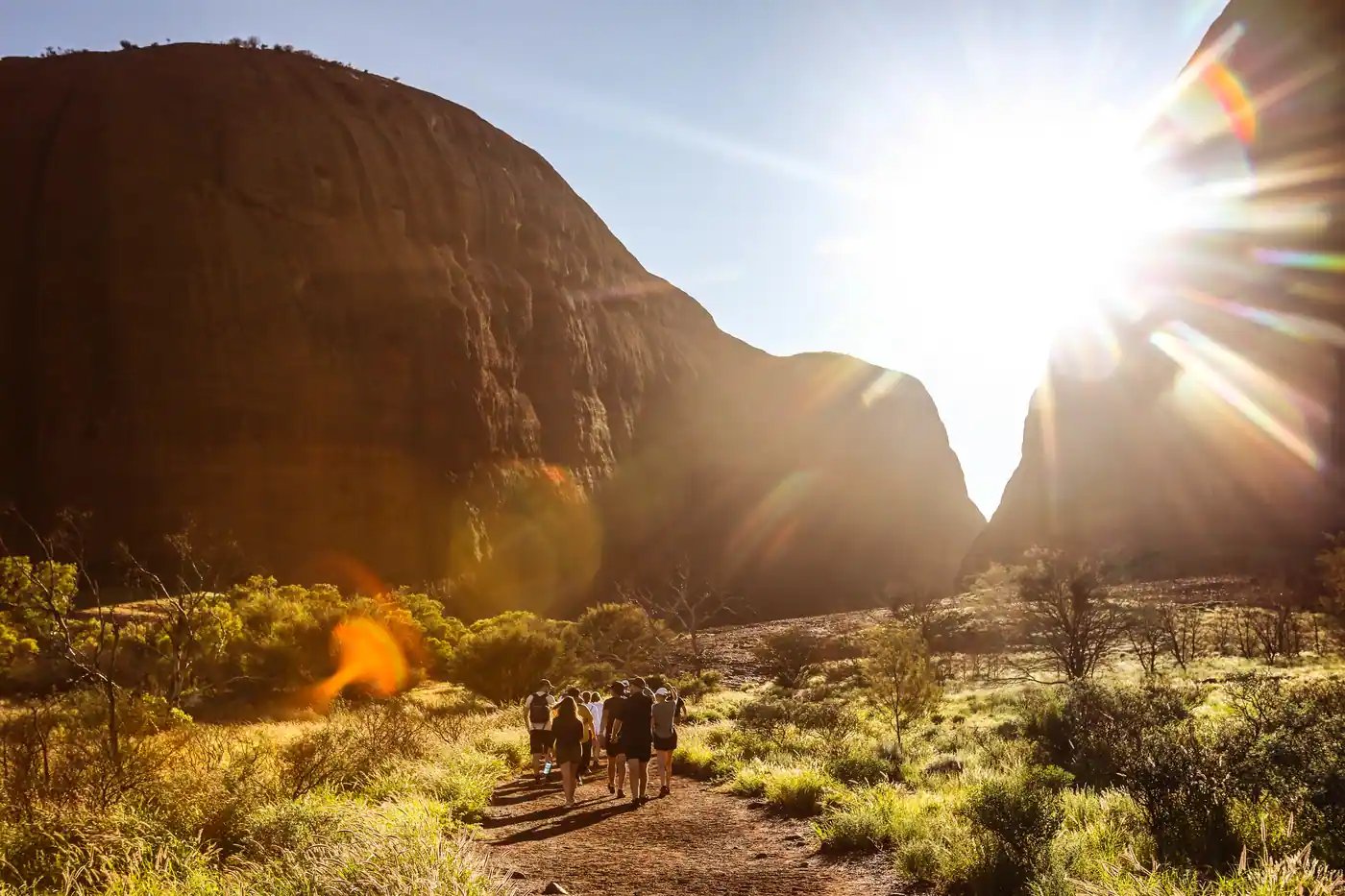 Gruppe på guidet tur ved Kata Tjuta i motlys.
