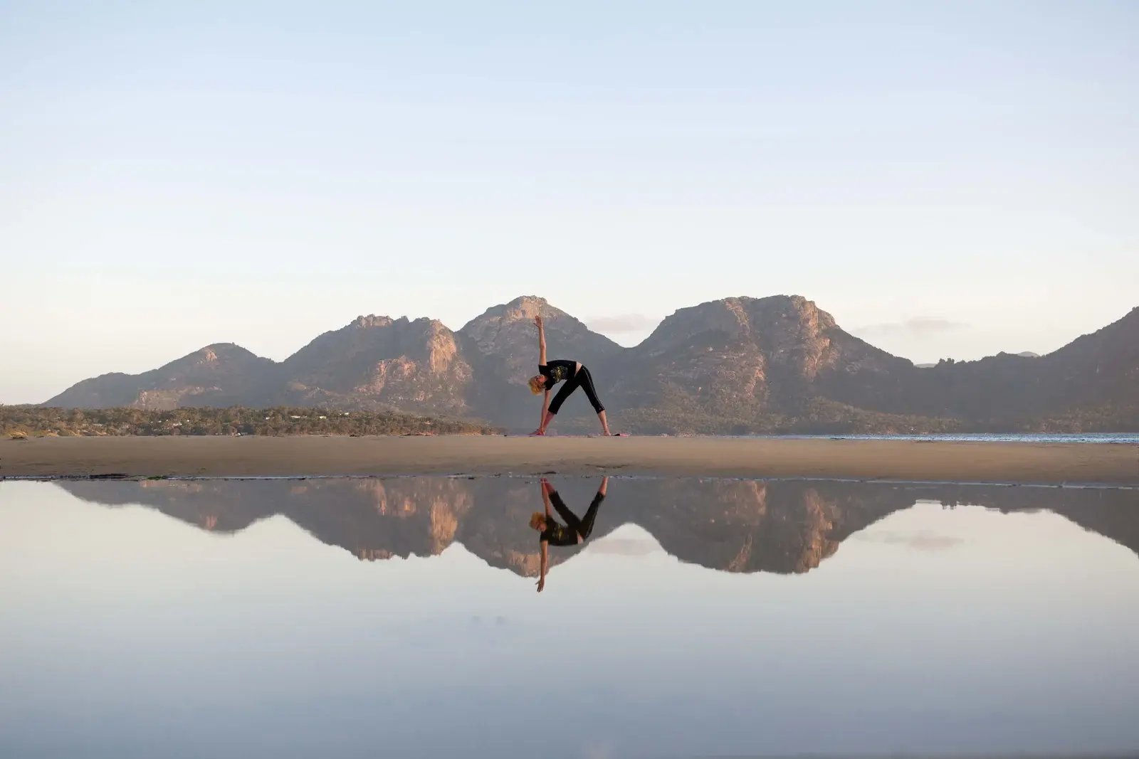Yoga på Muirs Beach med fjellene speilet i vannet.