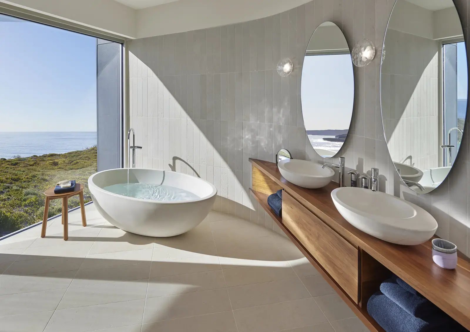 Bad i Remarkable Suite med to servanter og utsikt mot kysten.