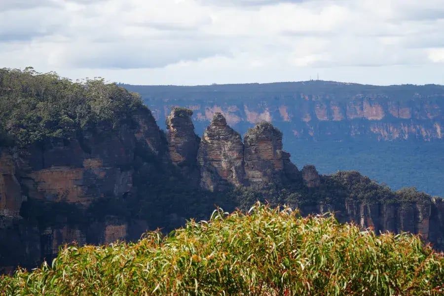 a breathtaking view of a rocky cliff face with steep, vertical layers of rock that have been eroded over time. T