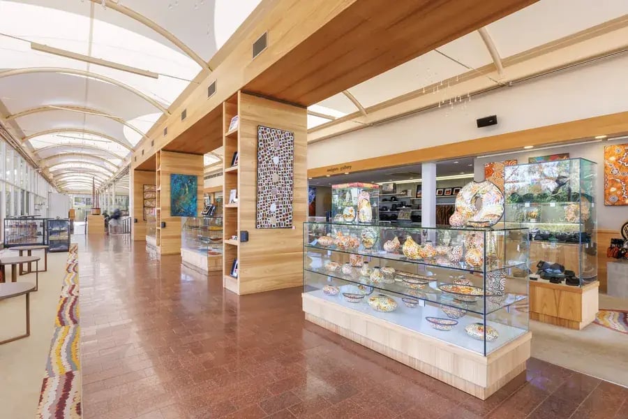 Mulgara Gallery med urfolkskunst og glassmontre i en lang, lys gang.