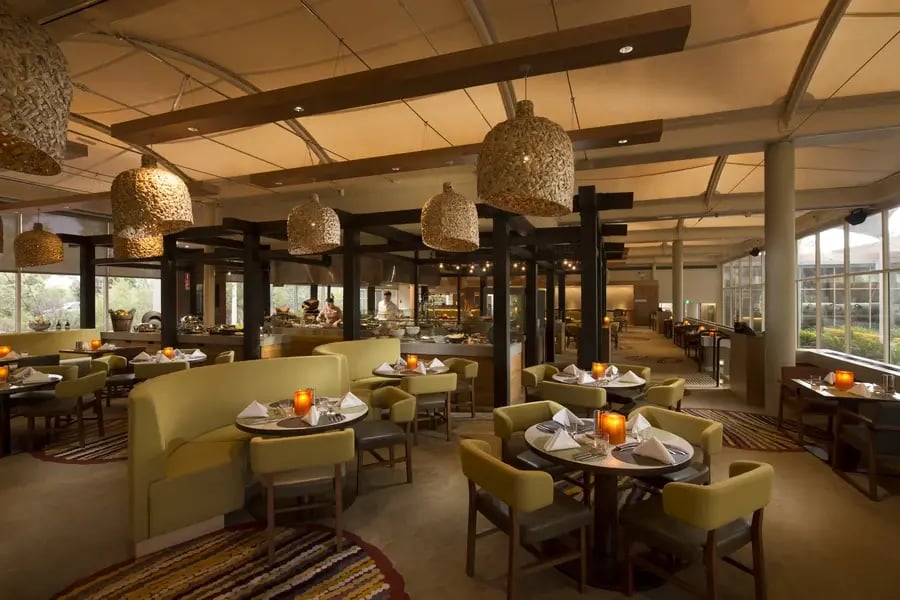 Ilkari-restauranten med dekkede bord og lamper av flettet materiale.