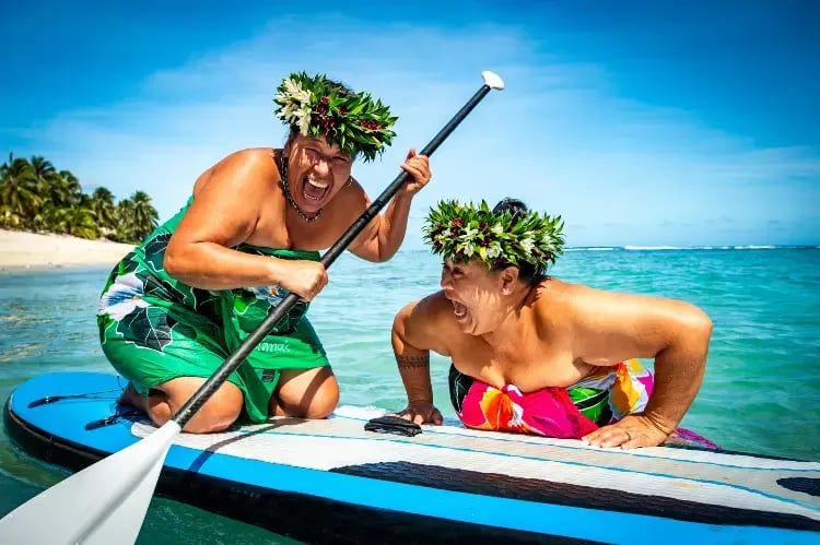 to glade cook island innbyggere på en SUP.