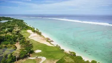 Korallkysten sett fra luften med golfbane og strand.