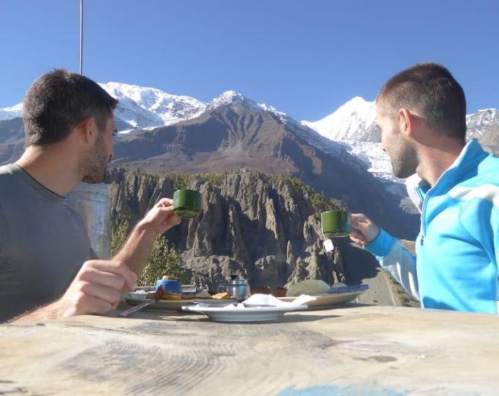 To menn nyter kopp kaffe foran fjellene i Himalaya To menn nyter kopp kaffe foran fjellene i Himalaya